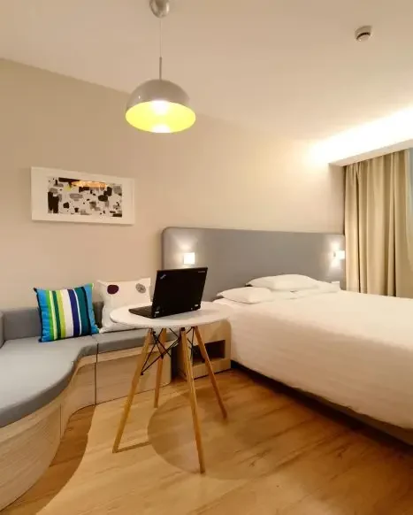 a modern bedroom design with unique curved bench style sofa with colorful accent pillows